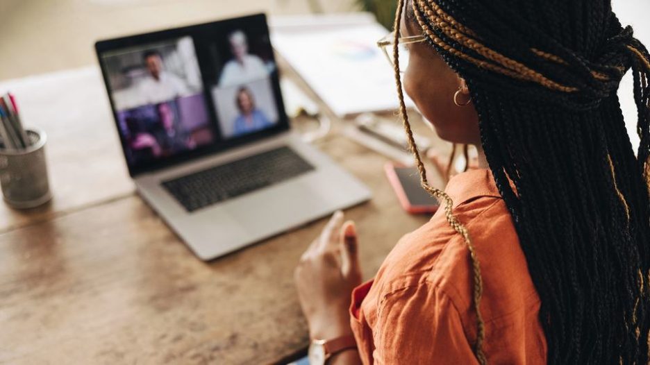 Female participating in group video call using laptop