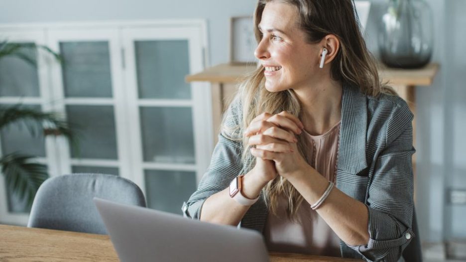 Smartly dressed business woman participating in webinar from home
