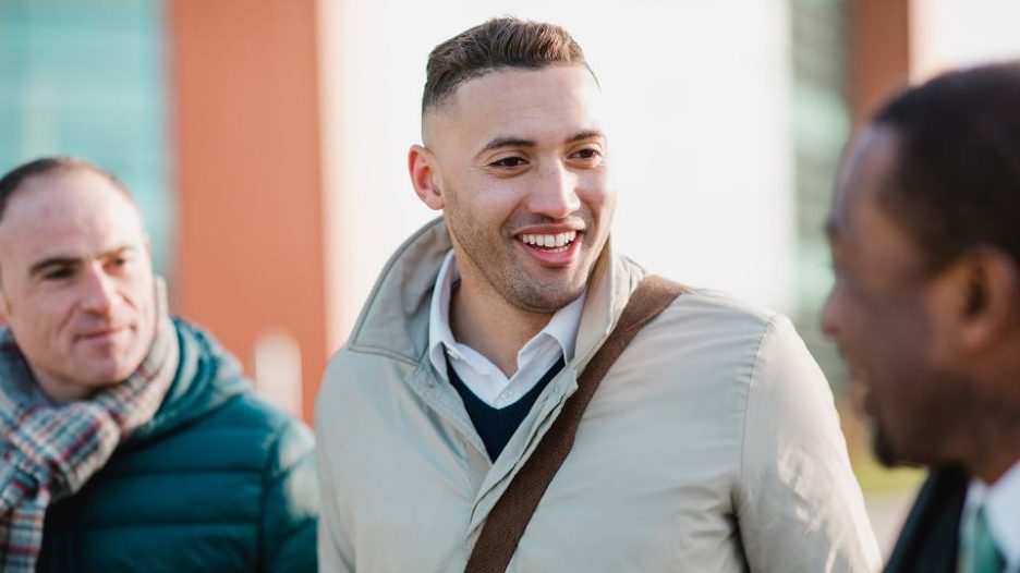 Professional males talking while walking outside
