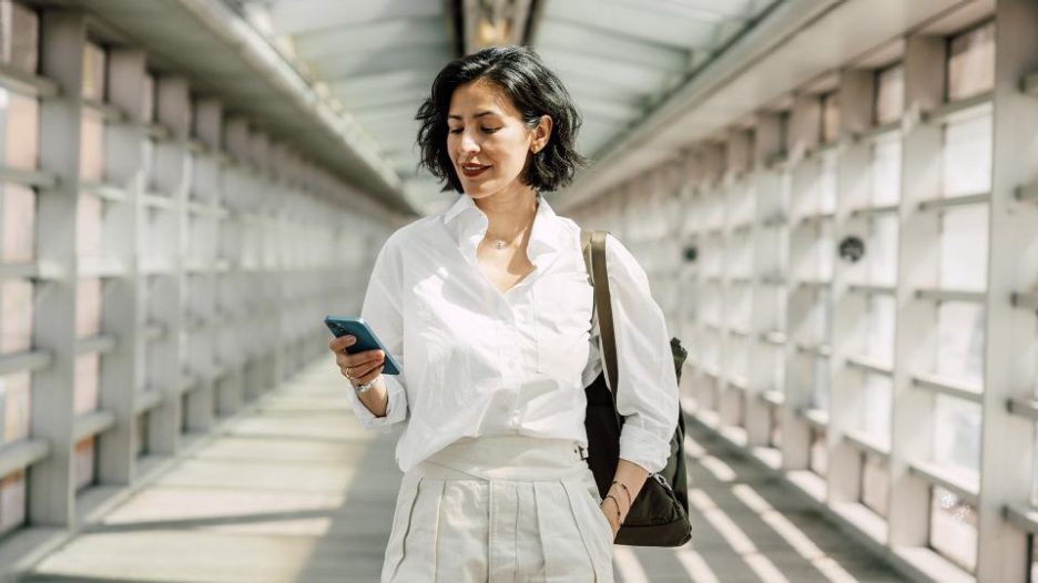 Businesswoman checking her phone while out on a walk