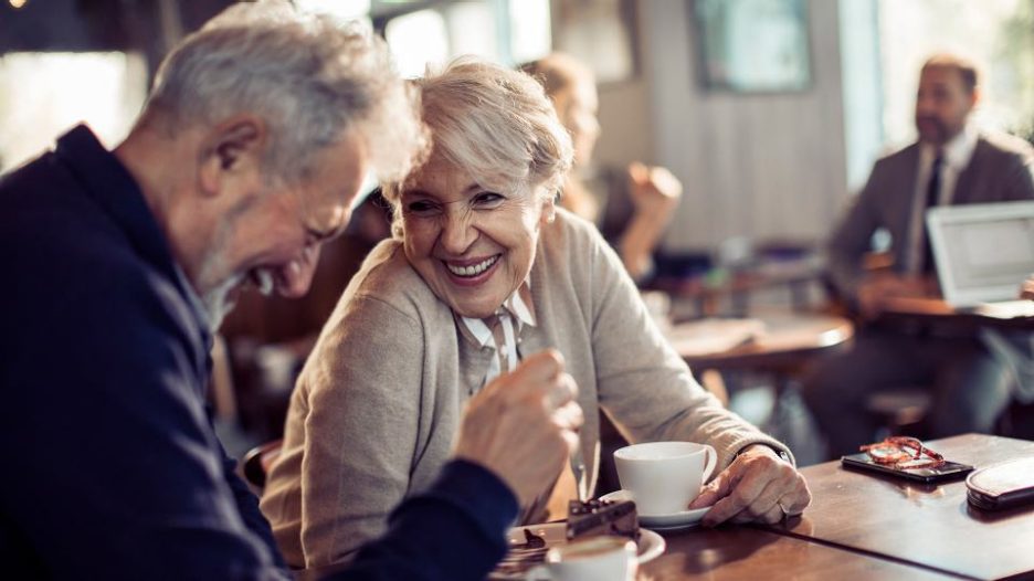 mature couple sharing a romantic memory while having coffee and cake at a cafe