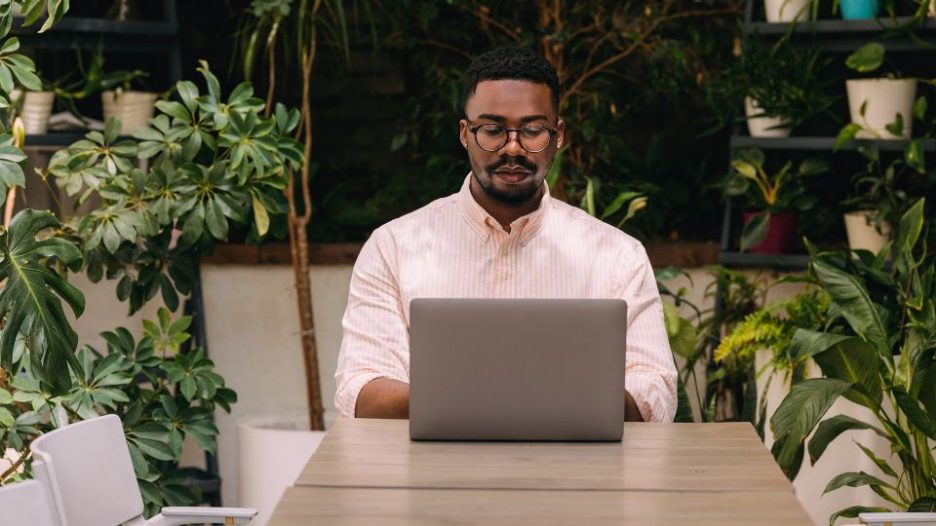 Embrace the casual yet professional atmosphere as an African-American man effortlessly combines work and leisure, creating a dynamic visual narrative of contemporary urban life.