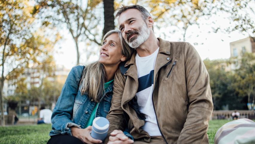 happy couple pausing to appreciate life while walking through a park together