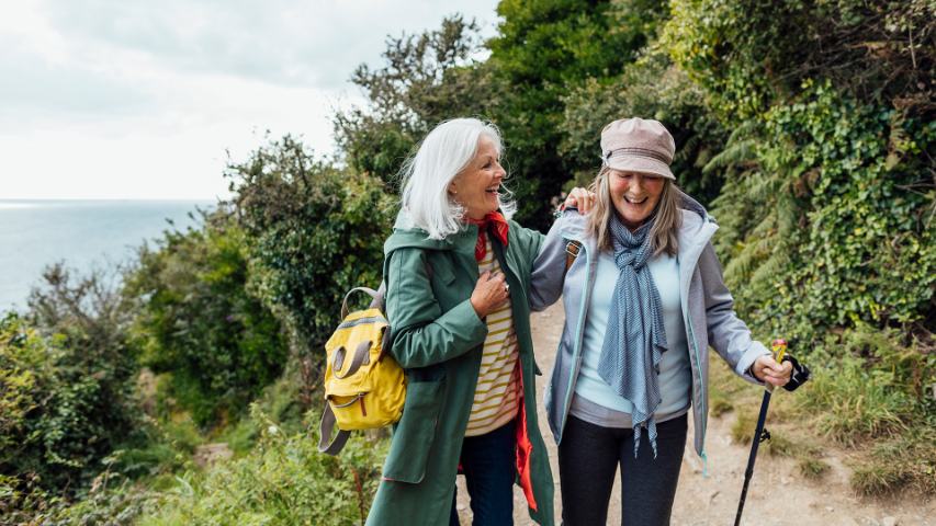 two mature female friends enjoying a gentle hike in nature