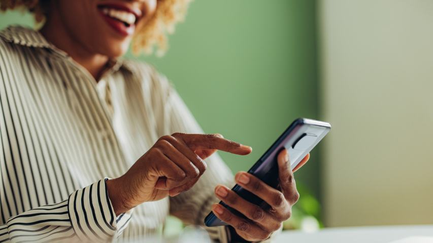 close up of a professional woman in her office smiling while she uses her phone