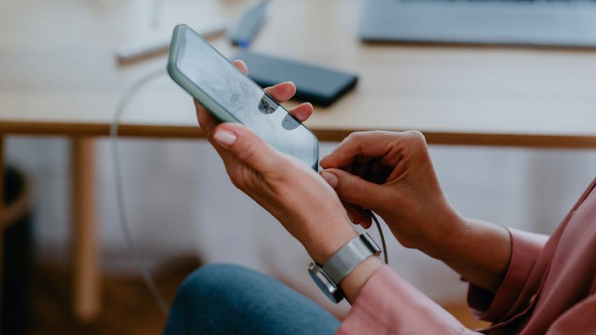 close up of a woman plugging in her phone to charge it