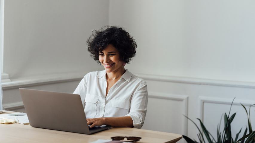 Female smiling while looking at laptop