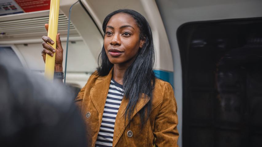 Female standing on train smiling