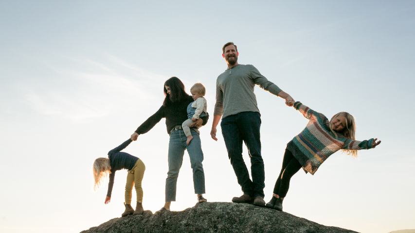 A family of 5 are leaving on top of a stone