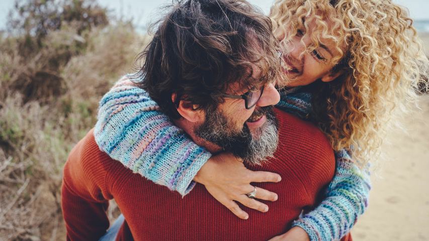 One man carry overjoyed woman in piggyback in outdoor leisure activity together having fun and laughing a lot. Happy mature people youth inside enjoy relationship and friendship carrying on the back