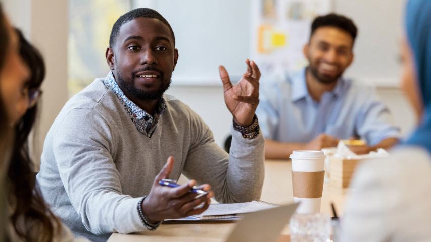 Professional male talking at group meeting