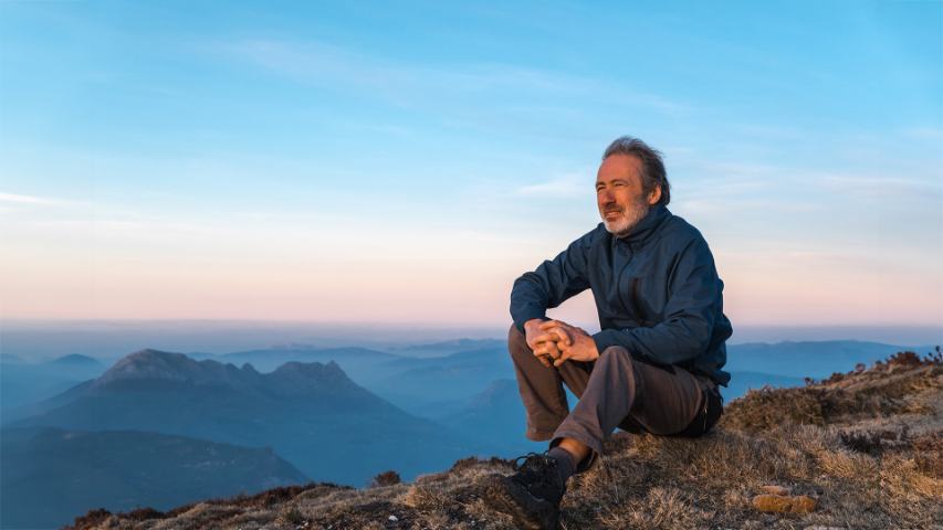 man sitting on mountaintop