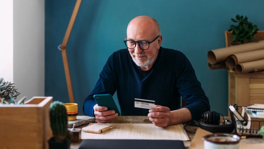 man using phone and credit card