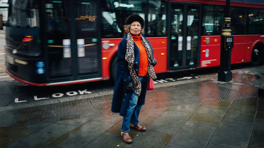 older woman in front of bus