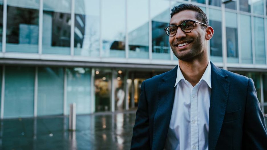 professional man is smiling and relaxed while walking through the office