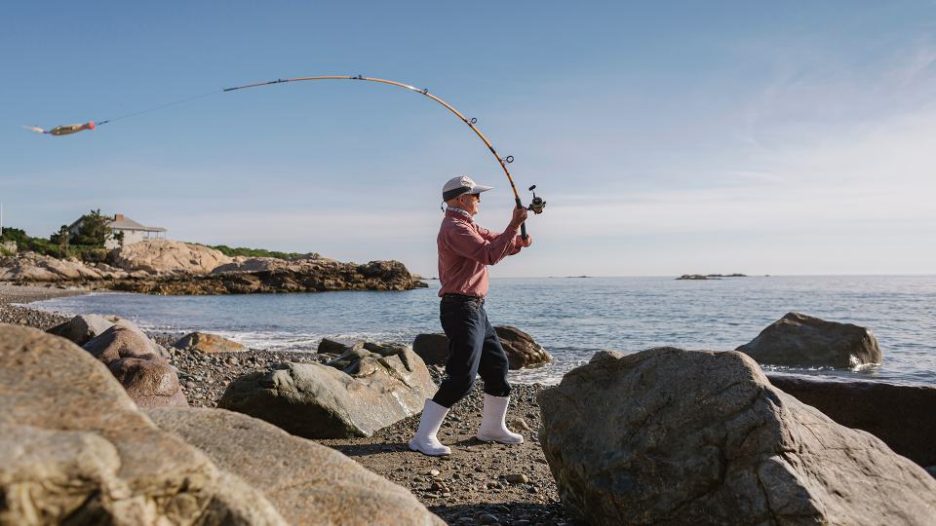 Active Senior man Surfcasting on a sunny day at the beach