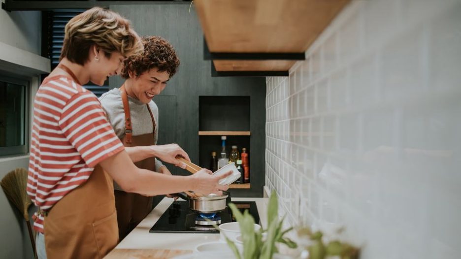 mother and teen son cooking together in a modern kitchen