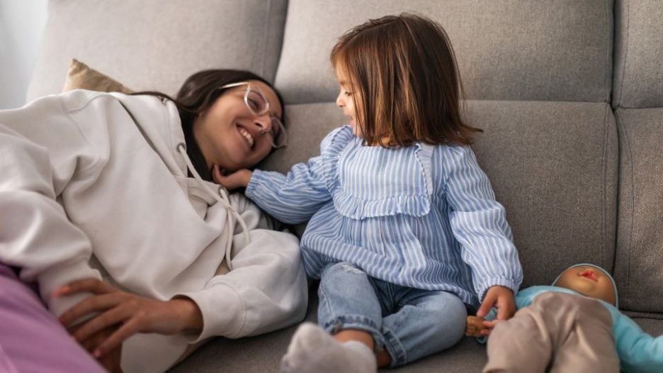 young woman with baby girl at home  playing on the couch