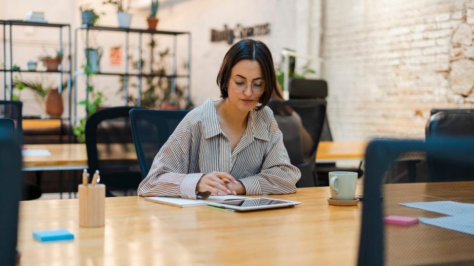 woman sitting at a table working in trendy open plan office