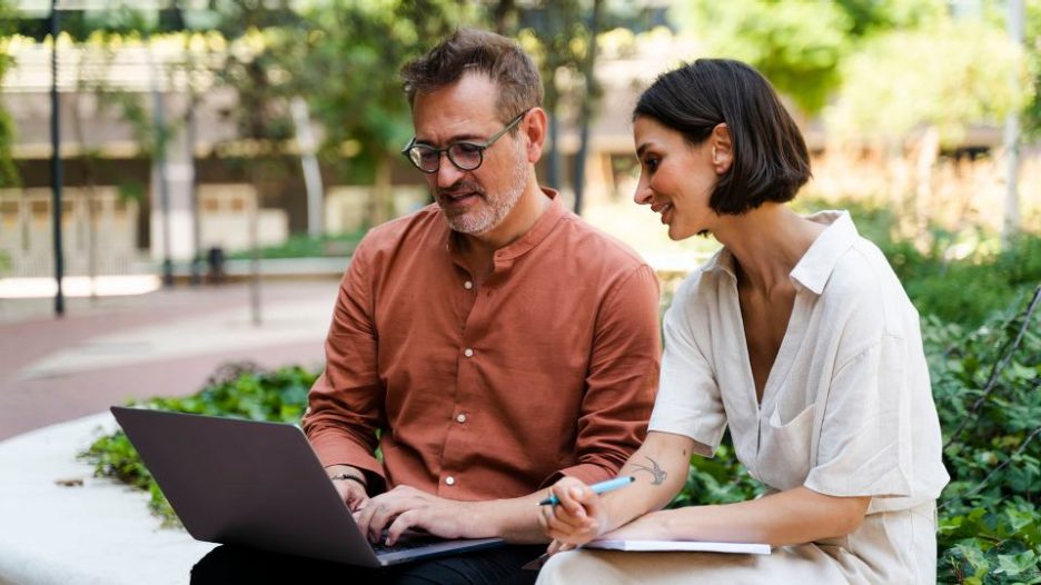 Male and females in meeting with laptop and tablet