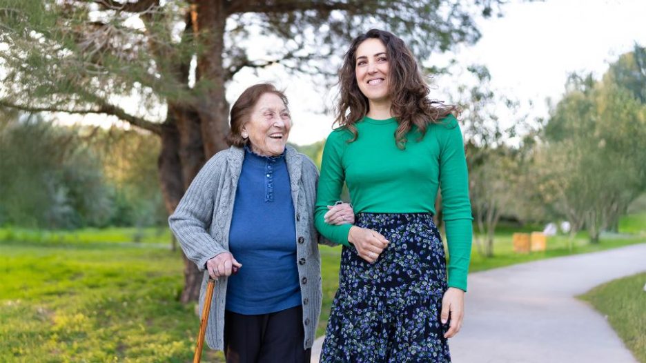 older woman walking in the park with granddaughter